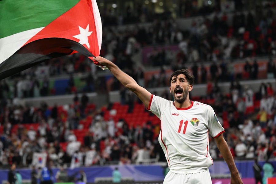 DOHA, QATAR - FEBRUARY 06: Yazan Alnaimat of Jordan celebrates the win with national flag during the AFC Asian Cup semi final match between Jordan and South Korea at Ahmad Bin Ali Stadium on February 06, 2024 in Doha, Qatar. (Photo by Kaz Photography/Getty Images)