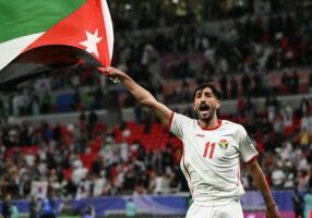 DOHA, QATAR - FEBRUARY 06: Yazan Alnaimat of Jordan celebrates the win with national flag during the AFC Asian Cup semi final match between Jordan and South Korea at Ahmad Bin Ali Stadium on February 06, 2024 in Doha, Qatar. (Photo by Kaz Photography/Getty Images)