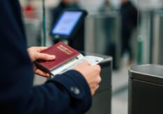person-holding-passport-and-boarding-pass-at-airport-security-gate-free-photo